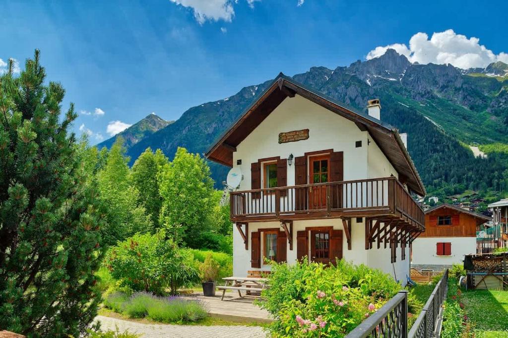 Chalet Heidi في شامونيه مون بلان: منزل بشرفة وجبال في الخلفية