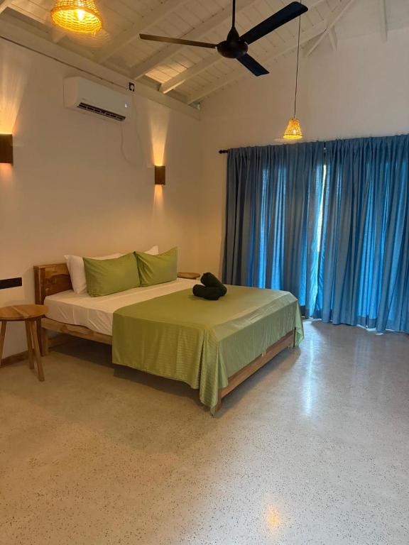 a bedroom with a bed and a ceiling fan at Sea Station in Habaraduwa Central