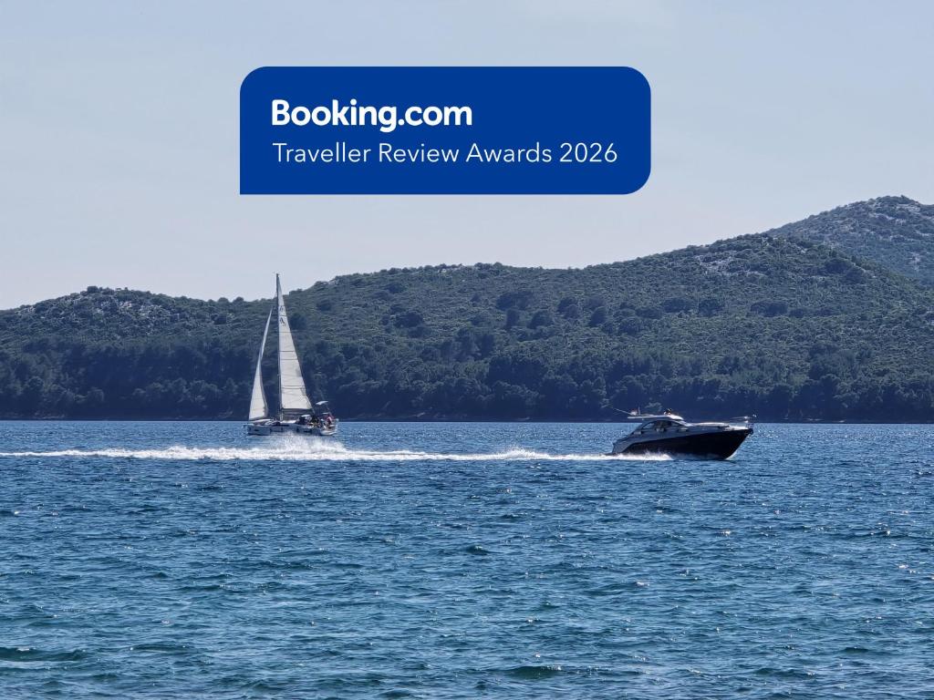 a boat in the water with a sailboat at SeaView Villa in Privlaka