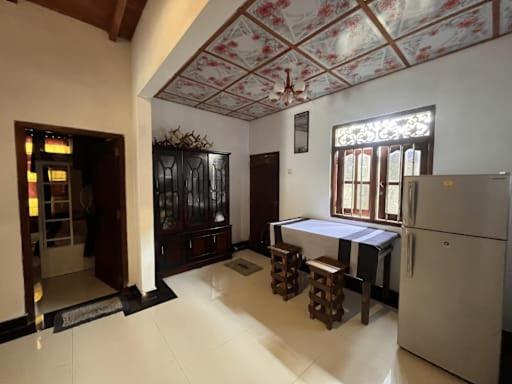 a kitchen with a table and a refrigerator in a room at Social Stay Hostal in Ahangama