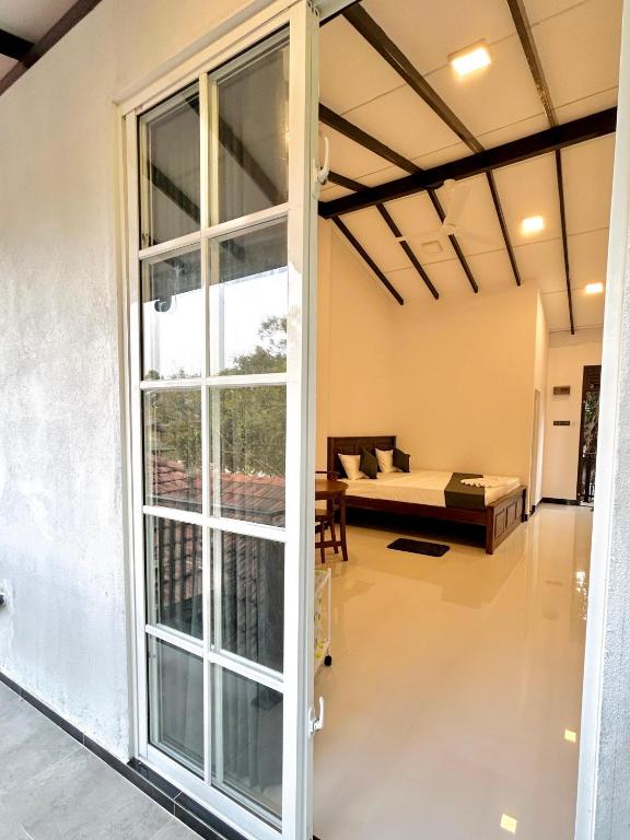 a living room with a couch and a large window at Rufero Transit Hotel in Katunayaka