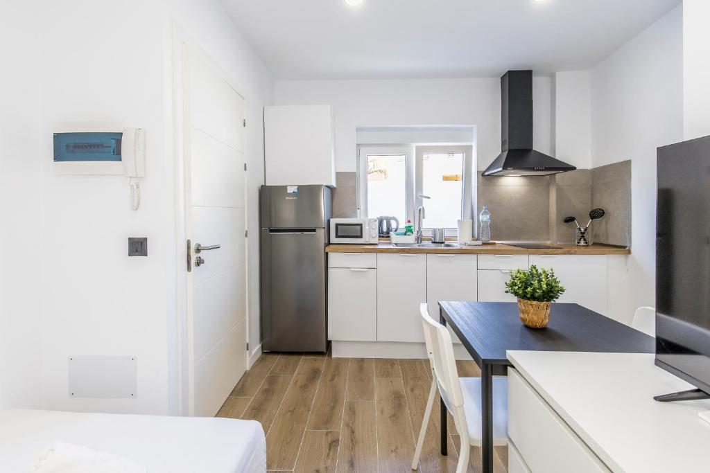 a kitchen with a table and a refrigerator at Charming Street Studio in Tegueste in Santa Cruz de Tenerife