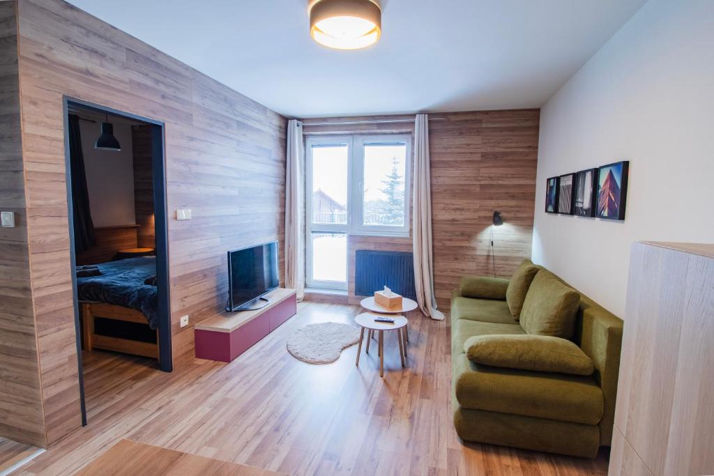 a living room with a couch and a television at Apartmán Tady 67 in Dolní Moravice