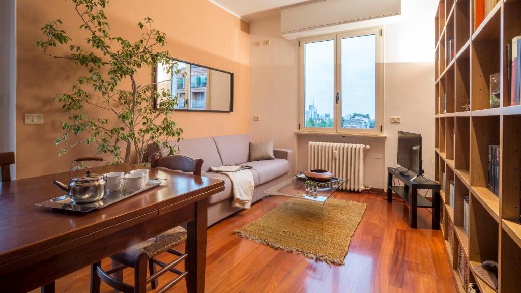 ein Wohnzimmer mit einem Sofa und einem Tisch in der Unterkunft ALTIDO Warm Family Flat for 6 with Terrace in Milan in Mailand