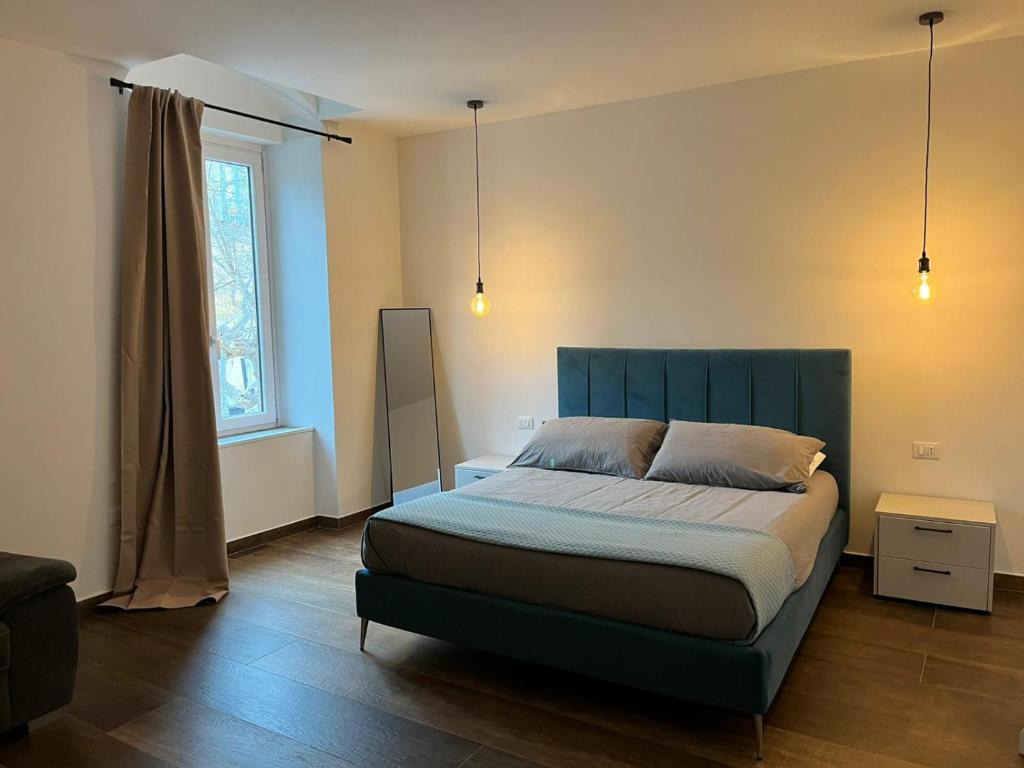 a bedroom with a bed with a blue headboard and a window at Garibaldi 105 in Castrovillari