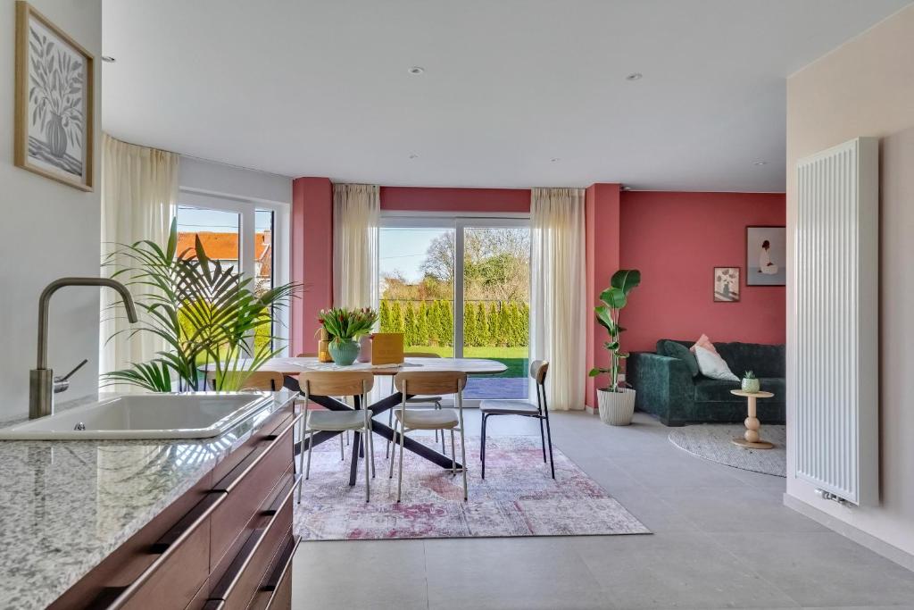 a kitchen with a table and chairs and a living room at 't Vennehuys - vakantiehuis nabij Bokrijk in Genk