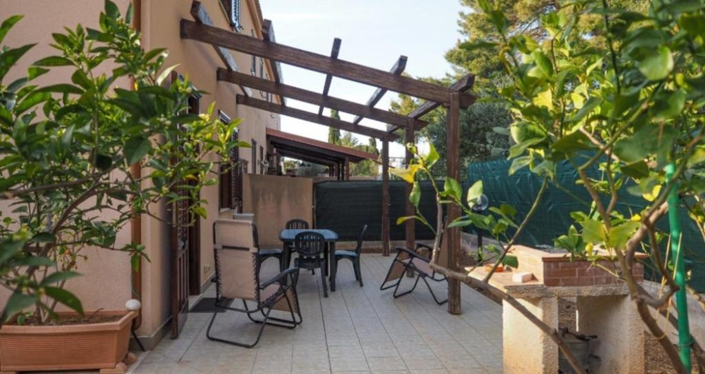 a patio with chairs and tables and potted plants at Villetta Vittoria in Macari