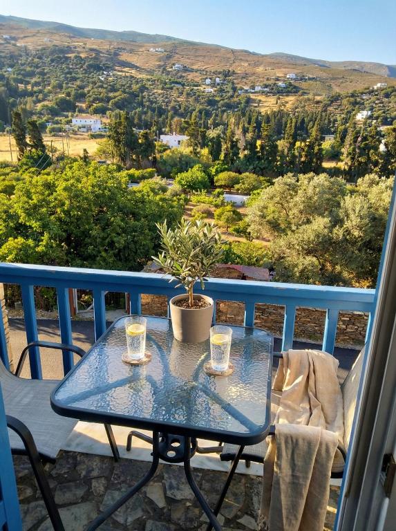 a blue table with two glasses on a balcony at Andros Guesthouses in Andros