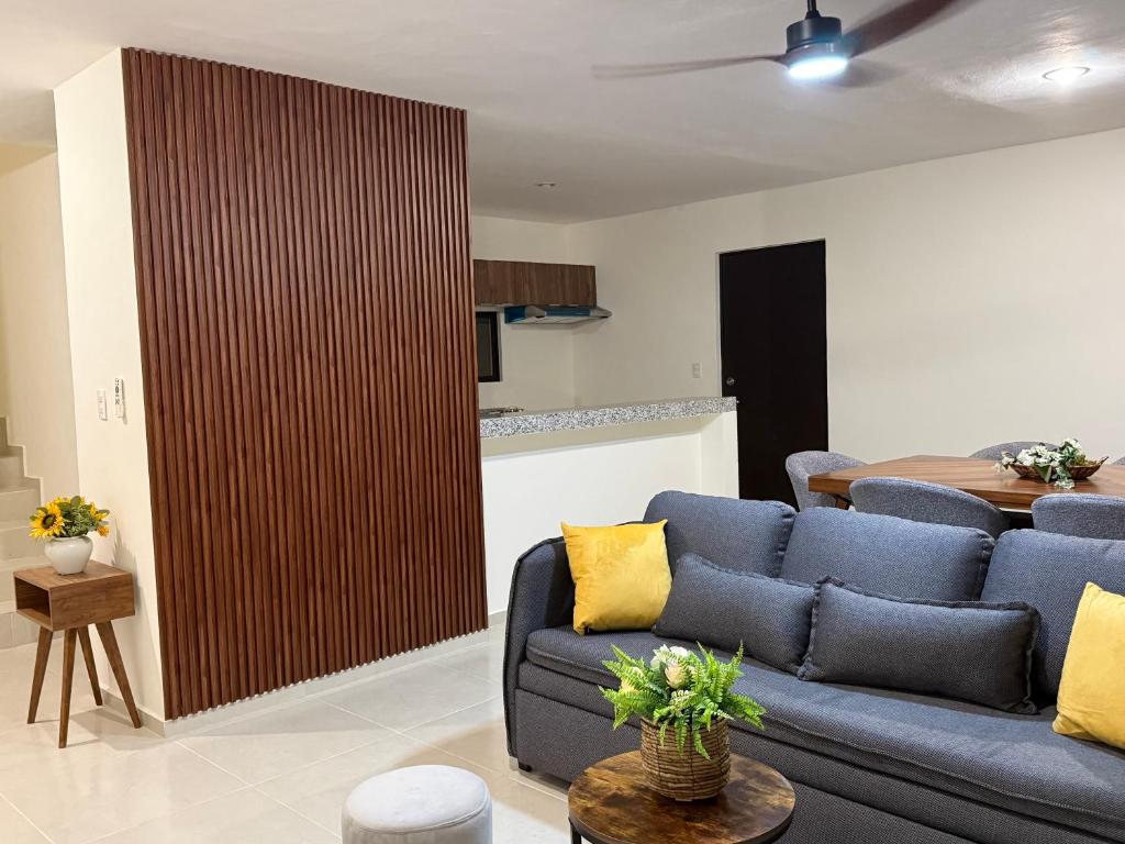 a living room with a blue couch and a table at Casa completa , dos Habitaciones con baño en cada cuarto in Mérida
