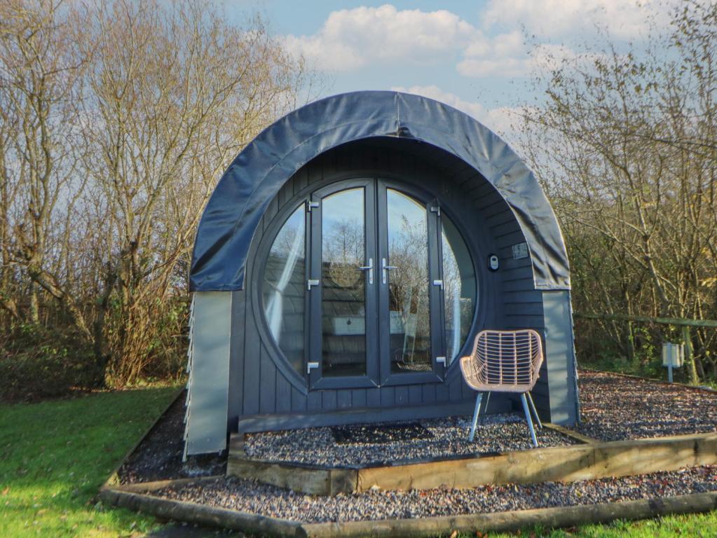 a blue dome house with a chair in the yard at Glamping Pod 5 - Gower in Swansea