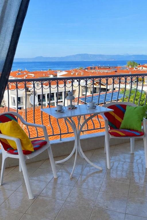 a table and chairs on a balcony with a view of the ocean at Rona Vista Suites amazing seaview 3 in Polychrono
