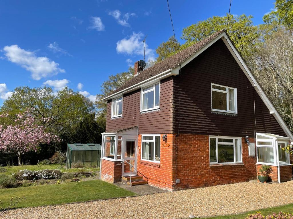 a red brick house with white windows on a yard at Roslyn in Romsey