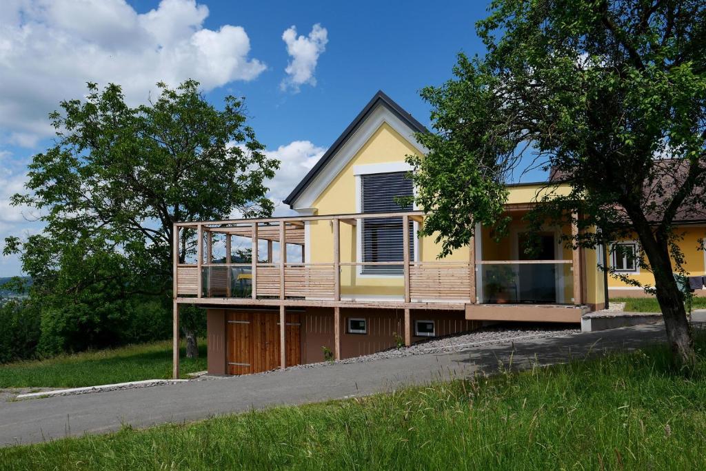 a yellow house with a deck on the side of it at Kellerstöckl Pachler in Bad Gleichenberg