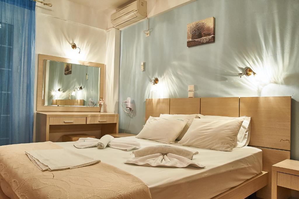 sypialnia z dużym łóżkiem i lustrem w obiekcie Villa Aroni w Elafónisos