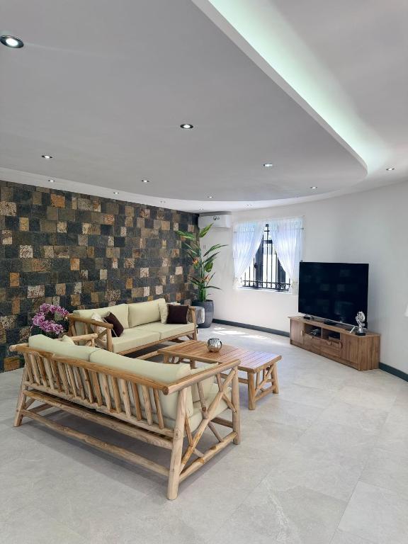 a living room with a couch and a tv at Villa Mauritius in Albion