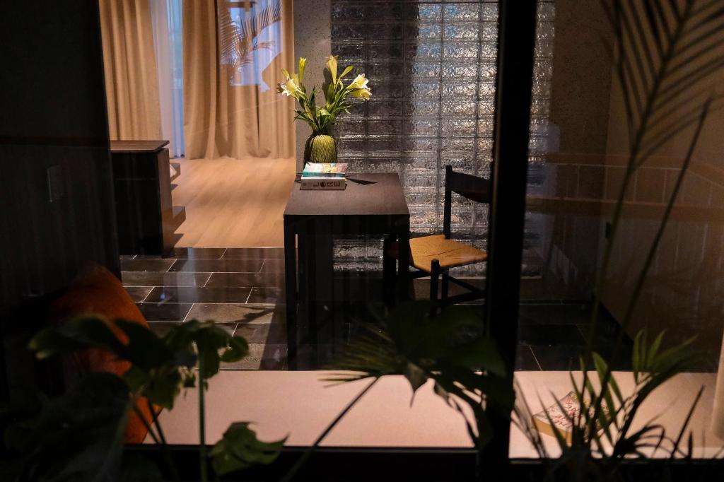 A small dining desk beside a glass partition, presented as a styled apartment corner.