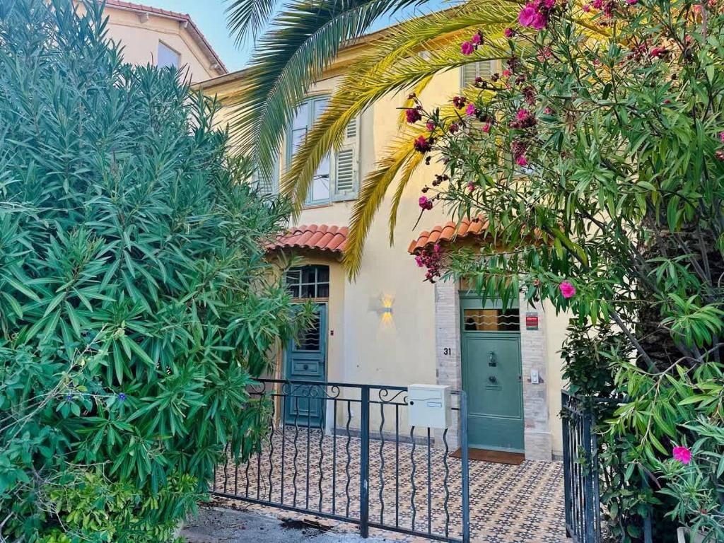 a house with a green door and some plants at Villa Leon - Centre Cannes - 4 chambres - Clim in Cannes