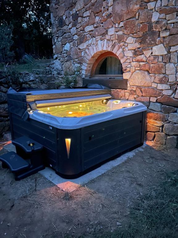a hot tub in front of a stone building at La Parenthèse ardéchoise - Spa et billard - Se ressourcer entre ville et forêt in Privas