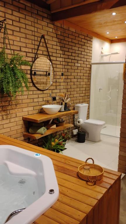 a bathroom with a tub and a toilet and a sink at Doce inga in Cairu