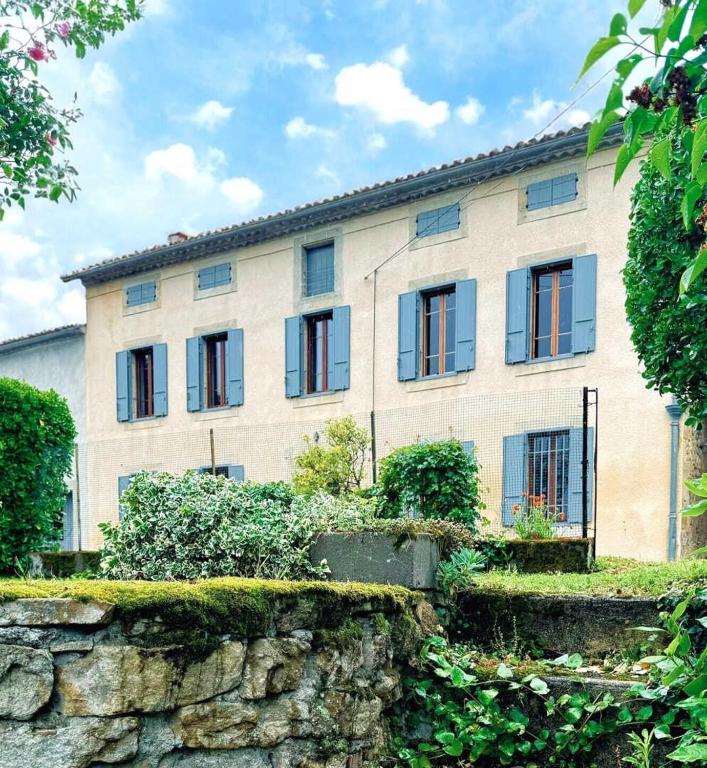 Laguzou في Saint-Julien-de-Briola: مبنى كبير ذو نوافذ على جدار حجري