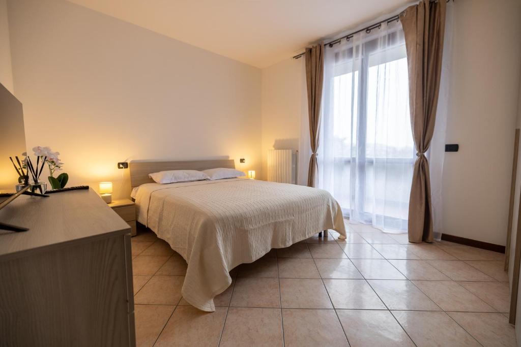 a bedroom with a bed and a large window at Casa Alexandra in Pantigliate