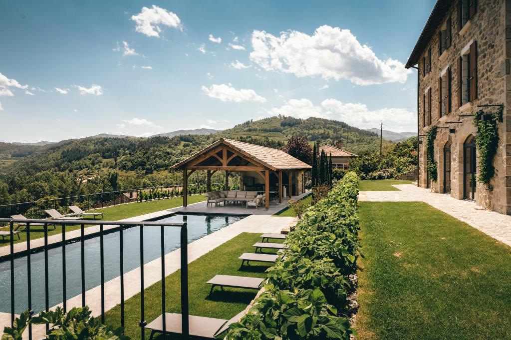 a pool with a gazebo next to a building at La ferme d'Edouard - Les Fermes Ardéchoises in Labatie-dʼAndaure