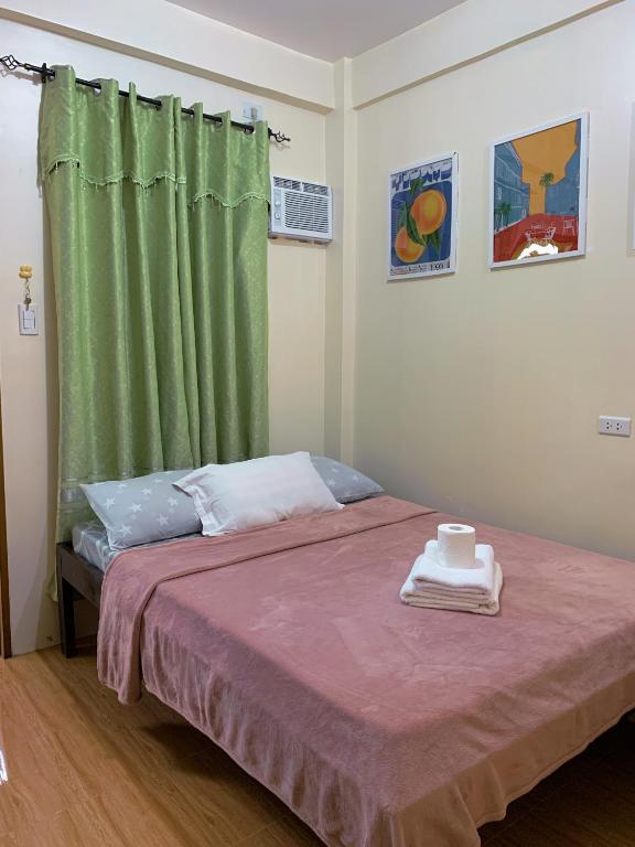 a bedroom with a bed with a green curtain at Cardo Rooms 2 minutes walk from the beach in General Luna