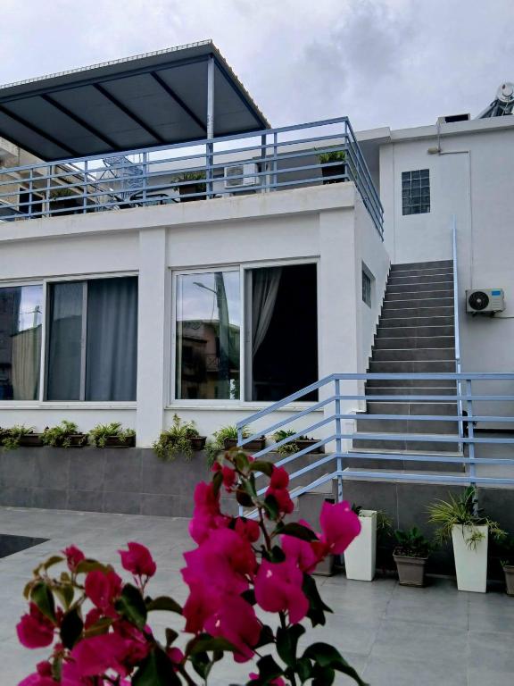 a house with stairs and pink flowers in front of it at SeaSuites Artemida in Artemida
