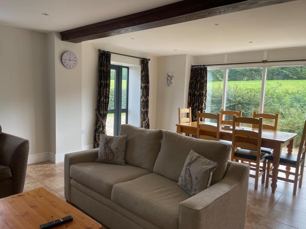 a living room with a couch and a table at Cumberwell Cottages-Dash Corner in South Wraxall