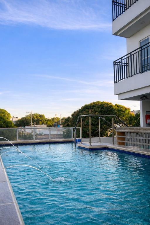 a swimming pool in front of a building at Adele Hotel in Ríohacha