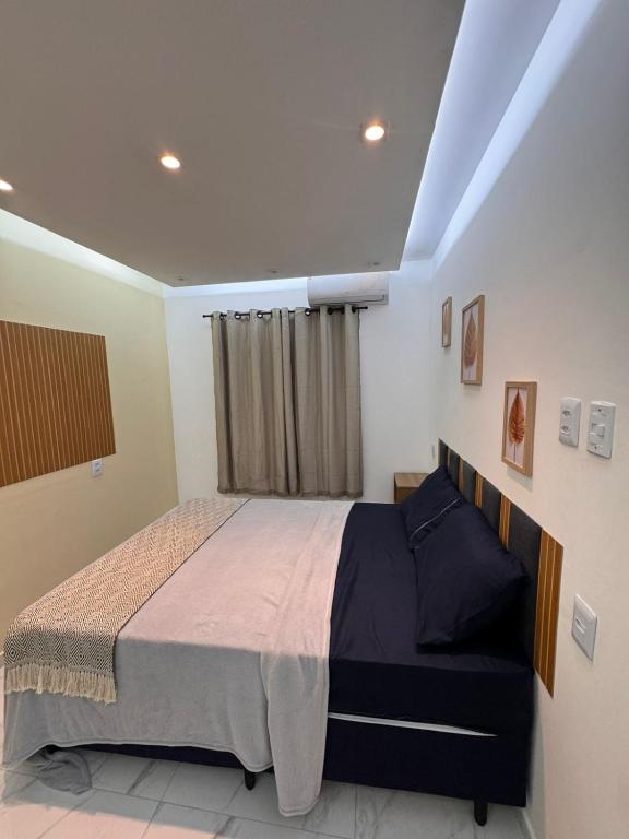 a bedroom with a large bed and a window at JB condominio b in Maceió