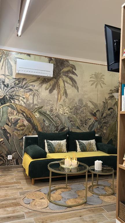 a living room with a couch and a palm mural at Guest house arboré in Saint-Loubès