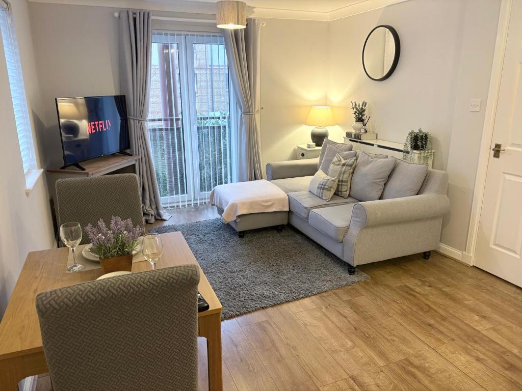 a living room with a couch and a table at Kinfirth Apartment in Ayr