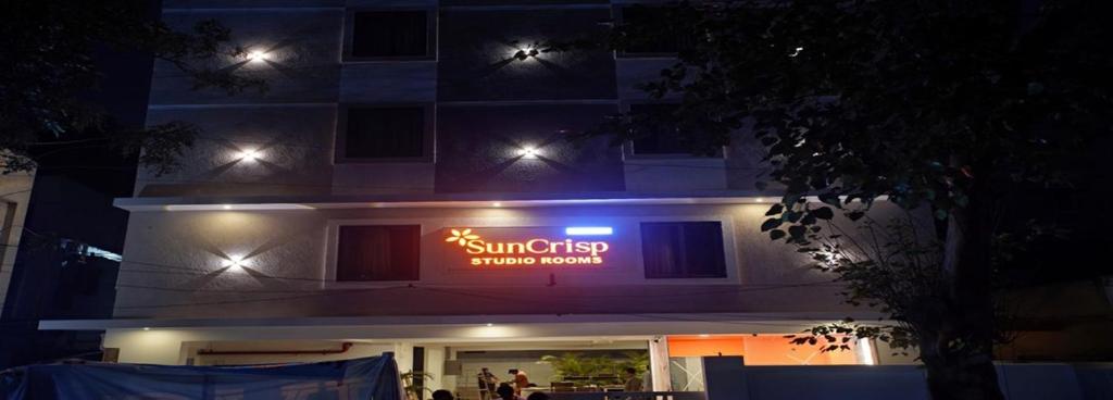 a building with a sign on it at night at Suncrisp Studio Rooms in Pedda Waltair
