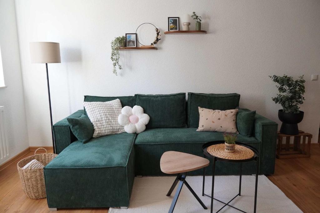 a living room with a green couch with pillows at Moor and More Loft in Monschau
