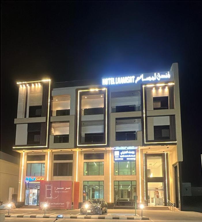 ein Gebäude mit einem Schild auf dem Dach bei Nacht in der Unterkunft فندق لمسات الخير الفندقية in Najran