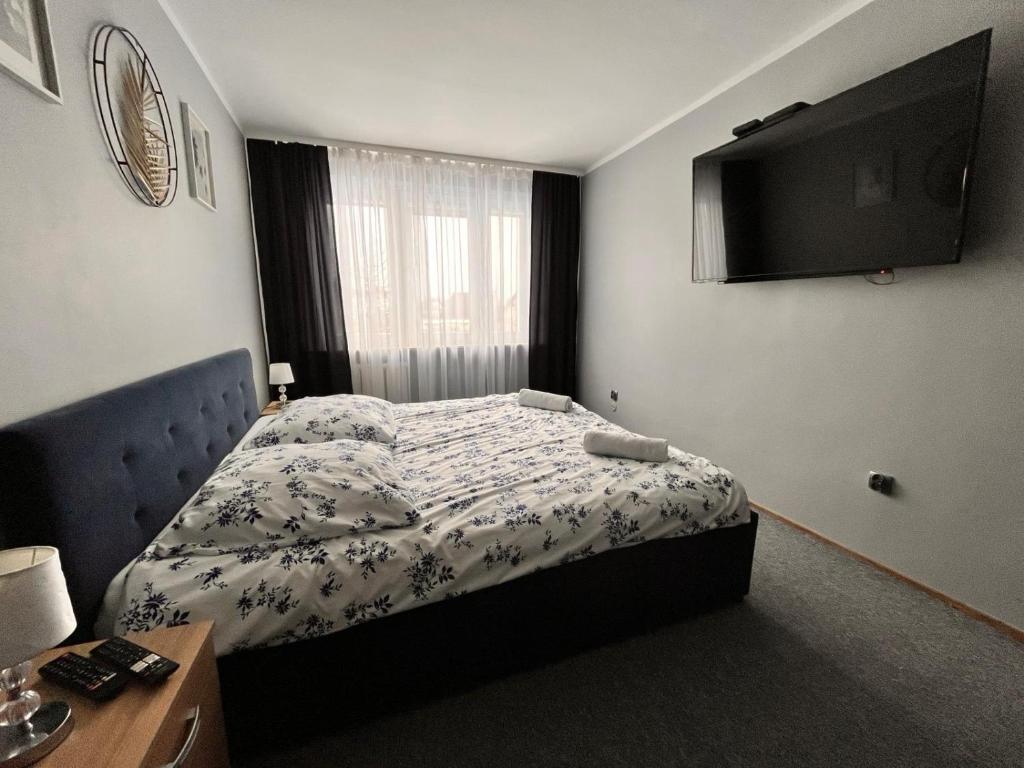 a bedroom with a bed and a television on the wall at Apartament Central Wałcz Residence in Wałcz