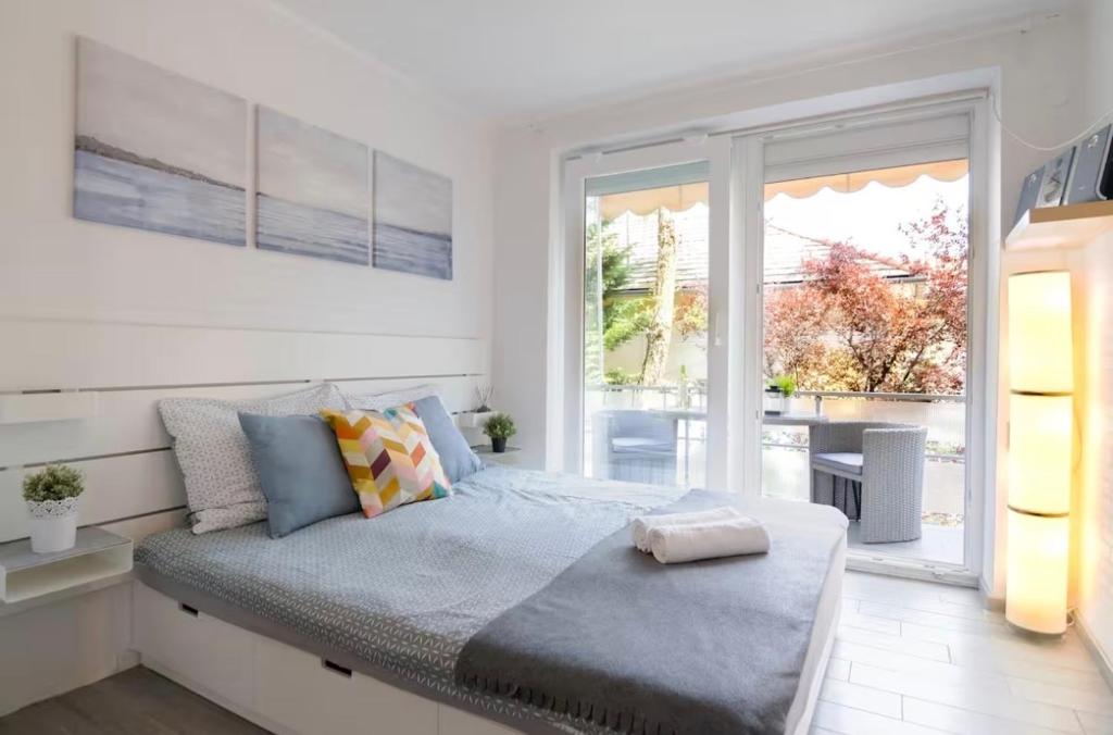 a bedroom with a bed and a large window at Blue Horizon Apartment in Balatonfüred