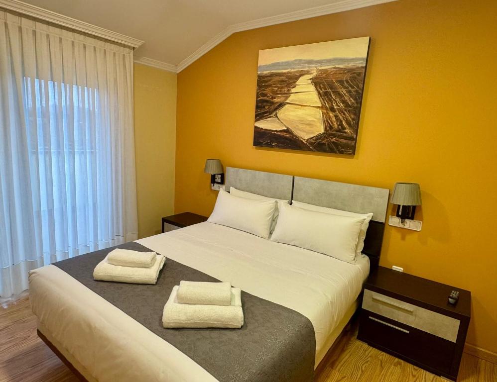 a bedroom with a large bed with two towels on it at Hotel Reigosa in Pontevedra