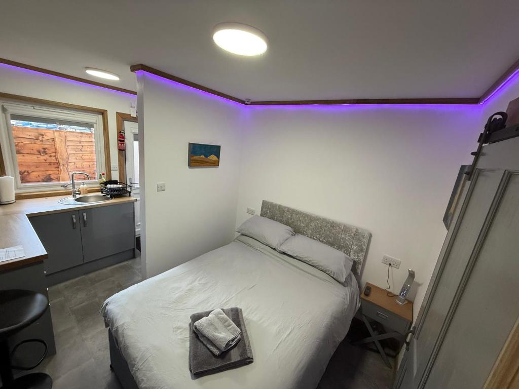 a bedroom with a bed and a sink with purple lights at Thurso Accommodation in Castletown