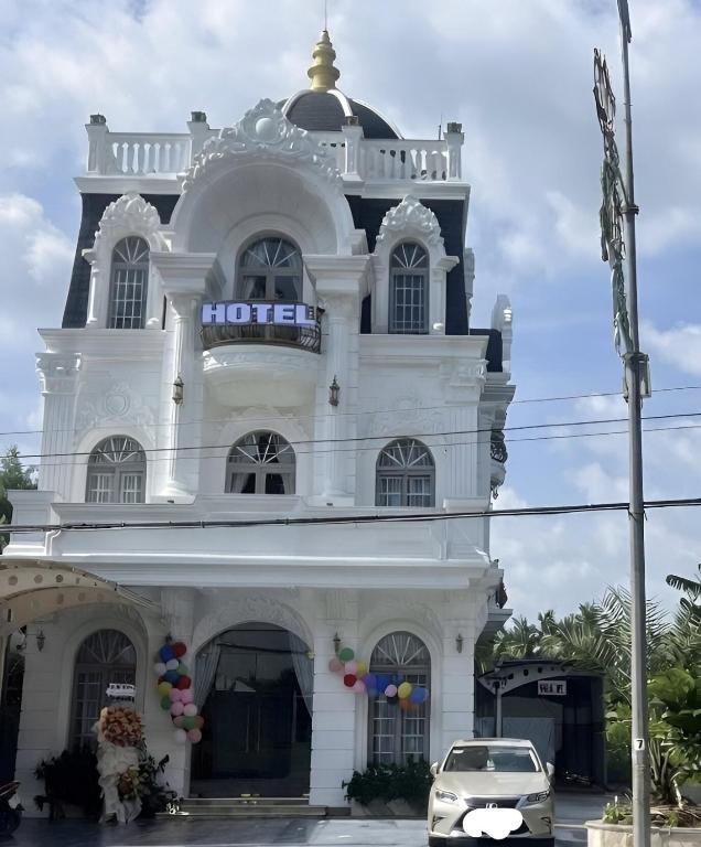 a white building with a clock tower on top at Huỳnh Thảo in Vũng Liêm