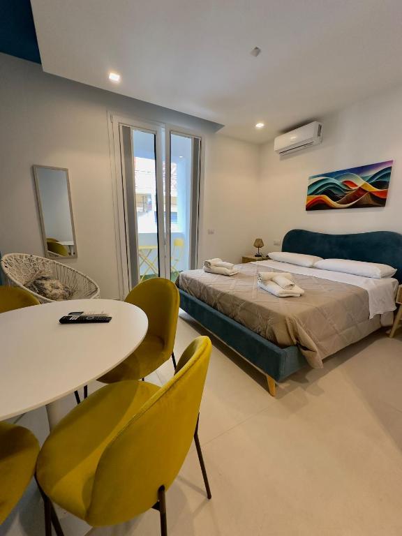 a bedroom with a bed and a table and chairs at I Faraglioni Comfort Rooms in Terrasini