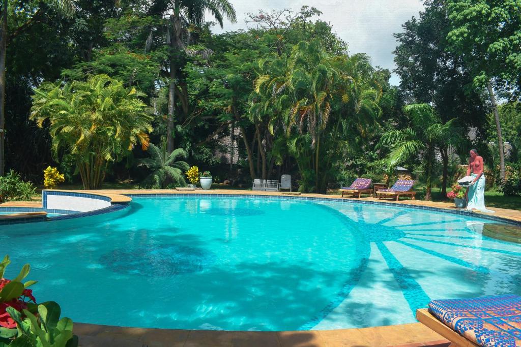 a large blue swimming pool with a person standing next to it at Tranquil Middle Apartment in Mtwapa