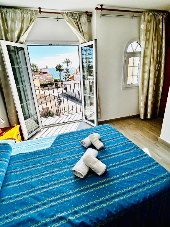 a bedroom with a blue bed with towels on it at Hostal Cala Verde in Villaricos