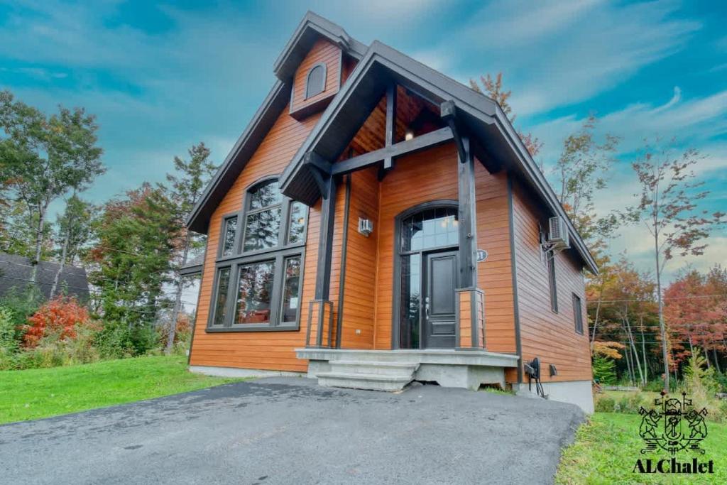 a small wooden house with a large window at Chalet charmant - Détente familiale in Scott