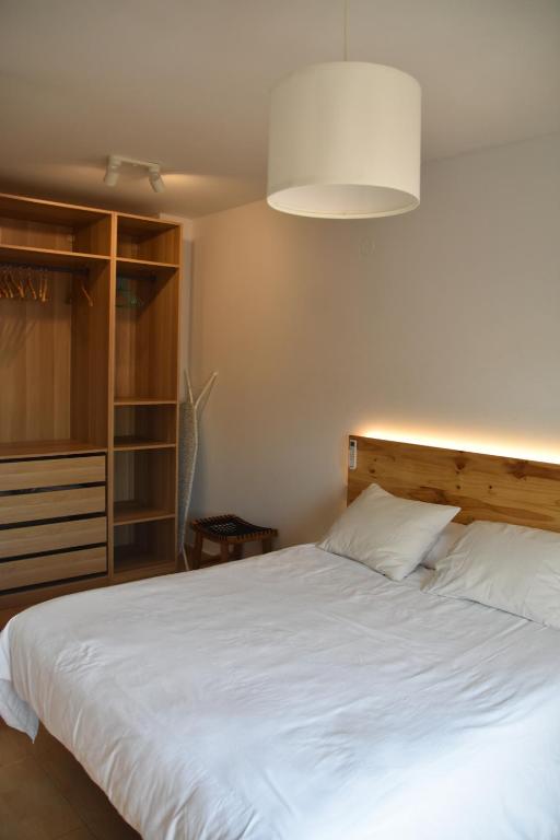 a bedroom with a large white bed and a lamp at Rincón Costero in Rincón de la Victoria