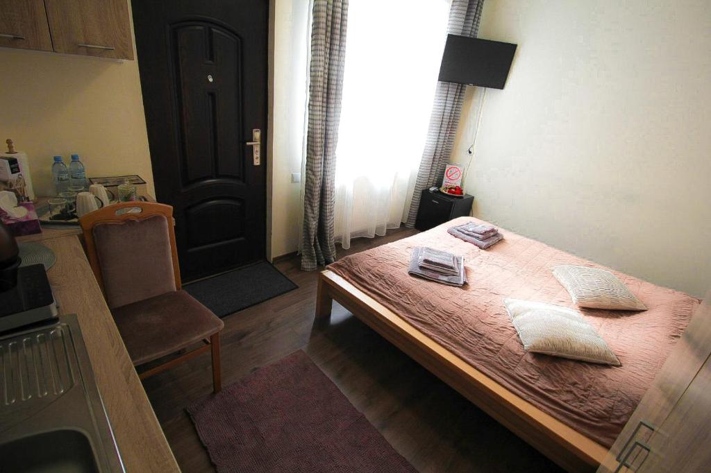 a room with a wooden table and a kitchen at Central garsoniera ap 3 in Târgu-Mureş