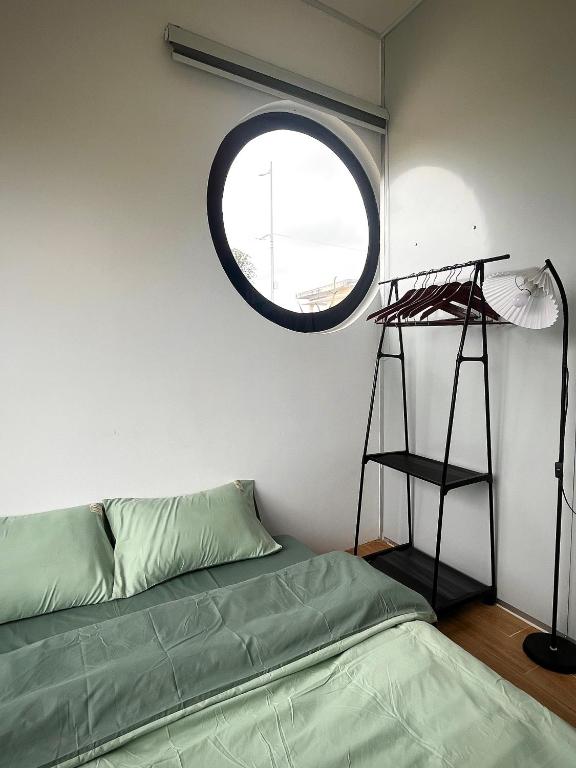 a room with a bed and a round window at Lunara Homestay in Phú Vang