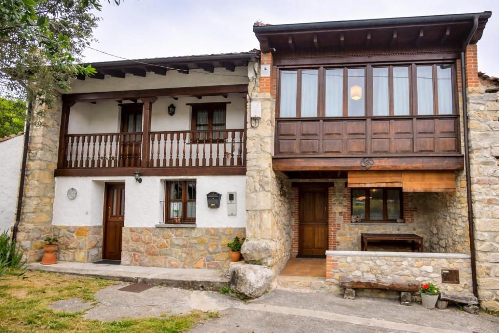 an exterior view of a house with a balcony at Llanes casa cerca de la Playa de Poo – Ekilore in Po