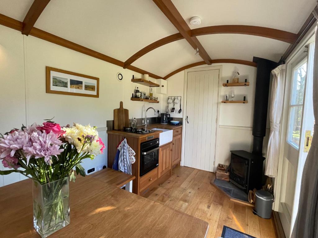 a vase of flowers on a table in a kitchen at Dartmoor Shepherds Hut at The Shrubbery, River Walkham, Horrabridge, Yelverton in Tavistock